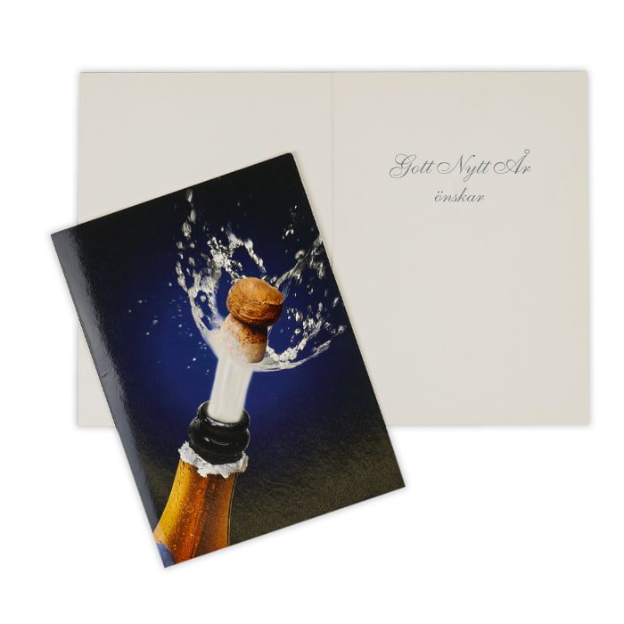 Ett häftigt dubbelt kort med kuvert, nyårskort med en champagnekork som skjuts ur flaskan på en mörkblå botten