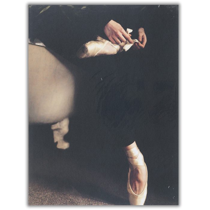 Ballet Fotograf: Bettina Tautzenberge Ett foto av en kvinna som knyter sina balettskor. Bilden är mörk och man ser bara kvinnans ben.