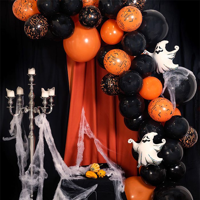 En båge med massor med ballonger i svart och orange och även folieballonger som spöken